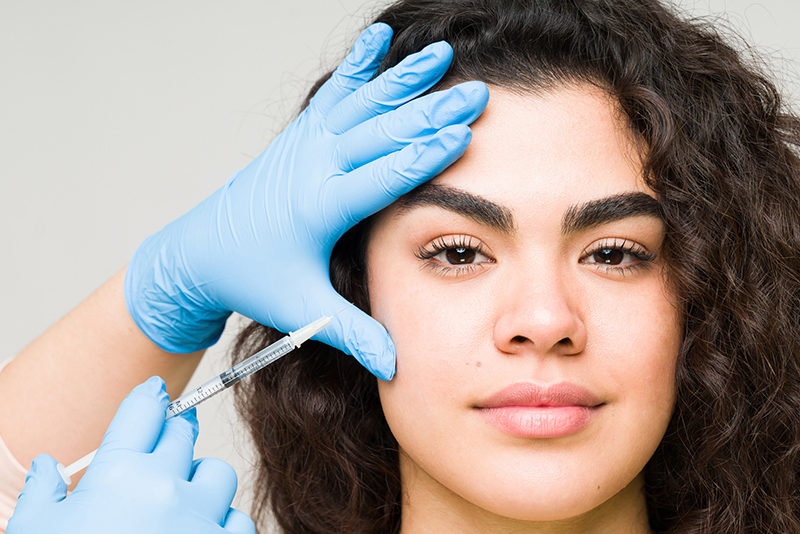 Cosmetologist giving a botulinum toxin or collagen injection